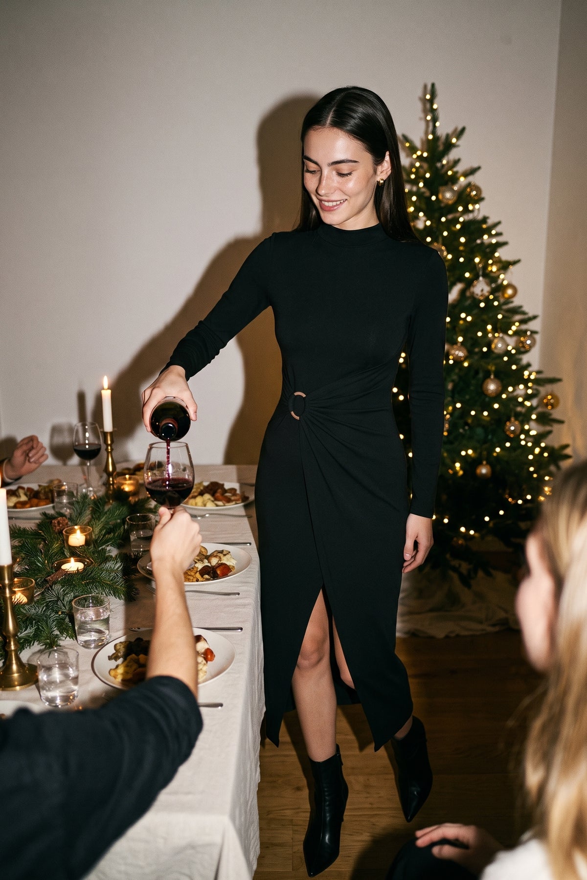 The Buckle Wrap Maxi Dress in black, pouring wine at a holiday dinner party