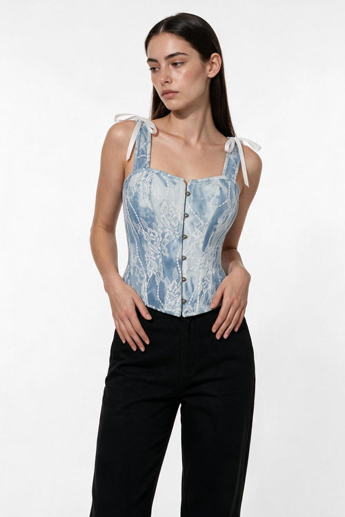 The Denim Lace Corset Top in light denim, three-quarter length view